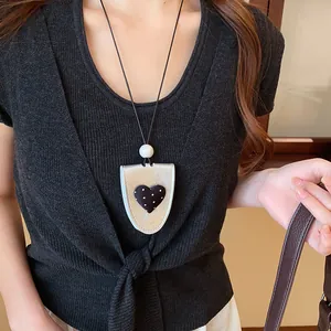 Detailaufnahme einer Leder-Sonnenbrillen-Clip-Halskette mit gepunktetem Herz-Design.