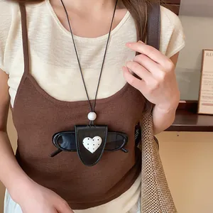 Detailansicht einer stilvollen herzförmigen Leder-Brillenhalter-Halskette an einem Modell.