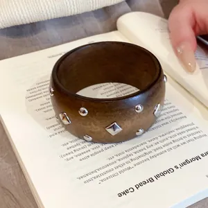 Brauner Harzarmreif im Ethno-Stil mit silbernen Nieten und Nischendesign