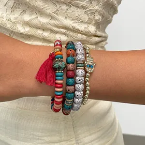 Close-up of 4-piece bohemian beaded bracelet set featuring red tassel and Hamsa hand charm