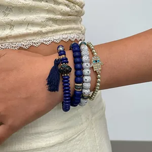 Detailed view of 4-piece beaded bracelet set featuring Hamsa hand and blue tassel