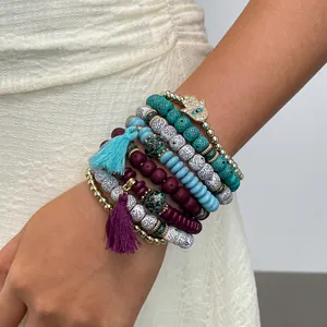 Detail shot of bohemian multi-layer beaded bracelet set with Hamsa hand charm and colorful tassels