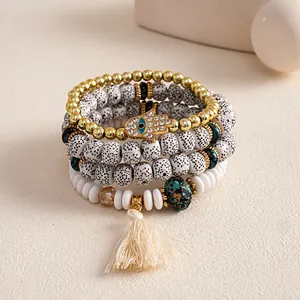 Detail view of four-piece beaded bracelet set with hamsa hand charm and tassel decoration.