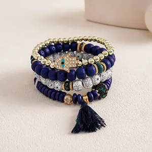 Close-up of Bohemian 4-piece stacked beaded bracelet set with Hamsa hand and tassel.
