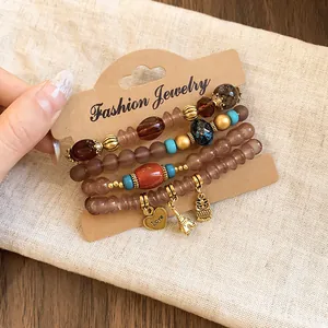 Close-up of Bohemian beaded bracelets with heart, owl, and Eiffel Tower charm details