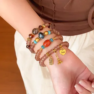 Close-up detail of bohemian beaded bracelet set with Eiffel Tower and owl charms