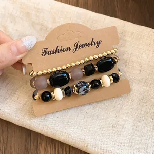 Close-up of a three-layered acrylic beaded bracelet set displayed on a kraft card holder