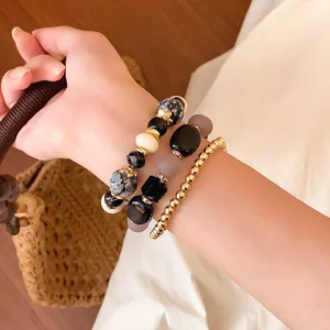 Set of three fashion beaded bracelets with acrylic and gold-tone beads on a wrist.