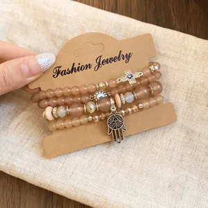 Detailed close-up of a stylish acrylic beaded bracelet set with Hamsa and Cross charms
