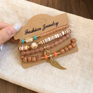 Detail view of 4-piece bohemian acrylic beaded bracelet set with wing charm