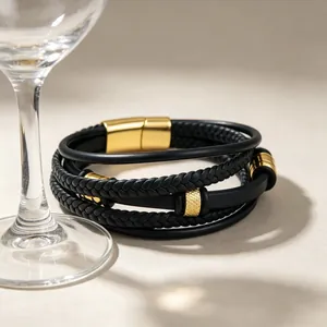 Detailansicht eines schwarzen Lederarmbands mit goldener Magnet-Stahlschließe und Struktur.