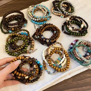 Set of bohemian multi-layered beaded bracelets with vintage charms on linen background