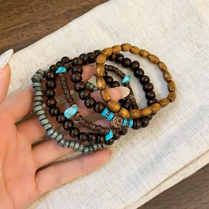 Close-up detail of Bohemian layered beaded bracelets with natural wood and turquoise accents.
