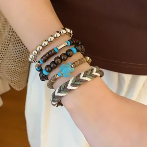 Close-up of bohemian layered beaded bracelet set with turtle charm on wrist.