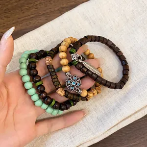 Detailed view of bohemian layered beaded bracelet set with wood beads and leaf charm.