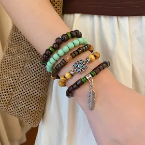 Close-up detail of Bohemian multilayer wooden beaded bracelet set featuring feather charm