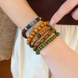 Close-up detail of Bohemian multi-layer wooden beaded bracelet set with Hamsa charm