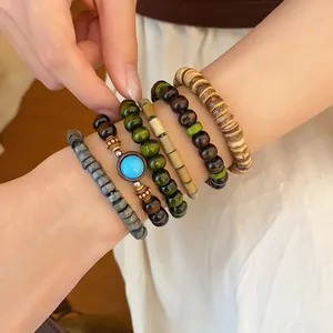 Close-up of bohemian stacked wood bead bracelets with turquoise detail on wrist