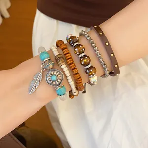 Detailed view of bohemian multi-layered beaded bracelet set with turquoise and feather charm