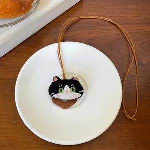 Detailweergave van schattige zwarte kat geborduurde brilhouder ketting op wit bord