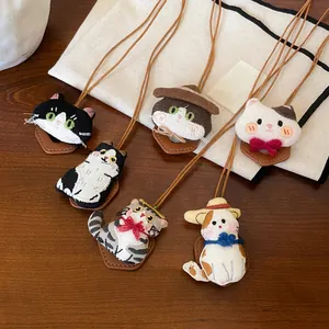 Set schattige handgemaakte geborduurde kattenkettingen en brillenclips op houten achtergrond.