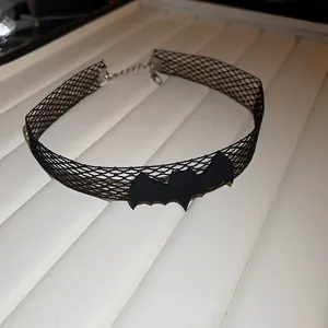 Macro view showing the intricate black mesh and bat charm of this Halloween choker necklace