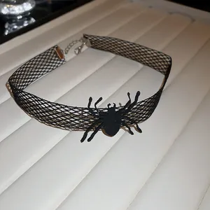 Close-up detail view of a black mesh Halloween spider choker necklace on a display tray