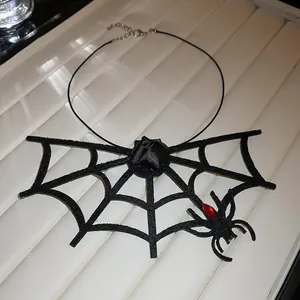 Detail view of black felt spider web necklace with a red gem spider for Halloween.