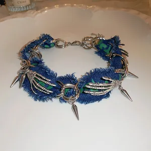 Detailed view of punk denim choker with silver skeleton hands and sharp spikes for Halloween