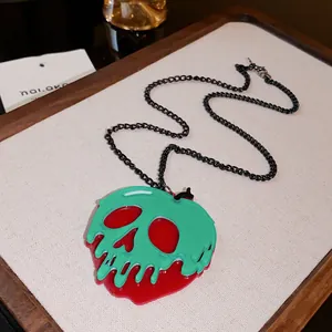Detailed view of Halloween poison apple necklace with melting skull pendant and black chain