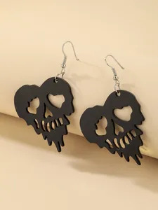 Macro detail view of black heart-shaped skull earrings for Halloween costume party