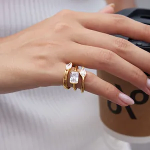 Close-up detail of three gold-plated titanium steel rings with clear zircon stones