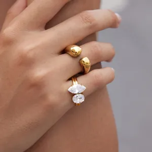 Detail view of gold stainless steel rings with water drop design and zircon stones