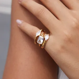Close-up of three gold titanium steel rings with marquise and emerald cut zircons