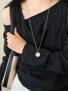 Detailansicht einer eleganten achteckigen Uhren-Anhänger-Halskette an einem Modell.