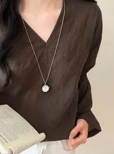 Vintage silberne Uhr Anhänger Halskette, getragen zu einem braunen Leinenhemd für Damen