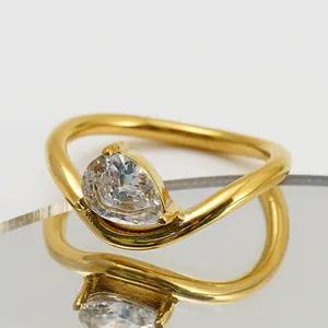 Detail macro view of an irregular gold band ring with a pear-shaped clear zircon stone