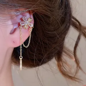 Close-up of an elegant zircon flower ear cuff with a delicate chain tassel detail