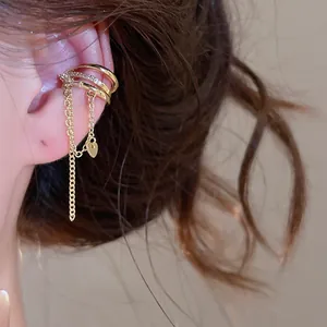 Detailed view of a gold-toned ear cuff with sparkling zircons and delicate tassels.