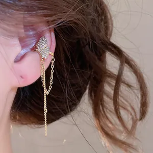 Detailed view of elegant gold butterfly ear cuff with sparkling zircon and long chain fringe