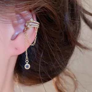 Close-up view of an elegant gold tassel ear cuff featuring zircon flowers and long chains.
