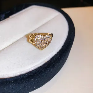 Close-up of golden heart-shaped ear cuff with sparkling zircon micro-pave setting