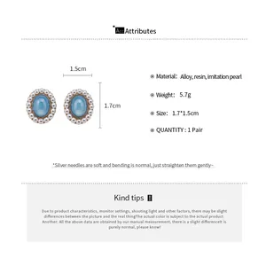 Detailed view of oval resin earrings with pearl border and size specifications