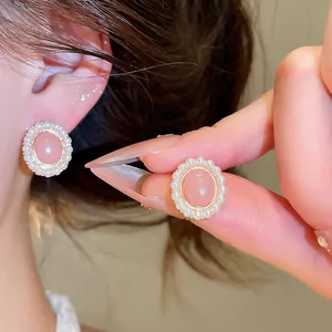 Macro view showing the detailed pearl border of elegant pink resin oval stud earrings