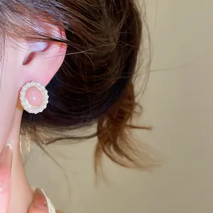 Close-up detail of elegant pink resin earrings with white pearl border decoration