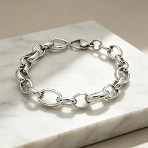 Vue détaillée d'un bracelet à maillons ovales en acier inoxydable poli sur marbre blanc