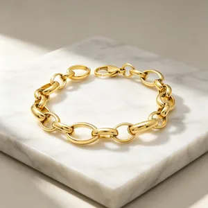 Vue détaillée d'un bracelet gourmette en acier inoxydable doré sur marbre blanc.