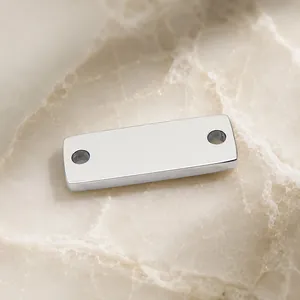Detailopname van gepolijste roestvrijstalen rechthoekige connector met twee gaten