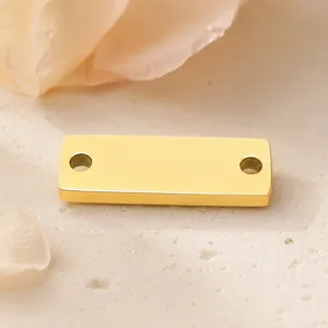 Close-up van een gepolijste goudkleurige roestvrijstalen rechthoekige 2-gats sieradenconnector.