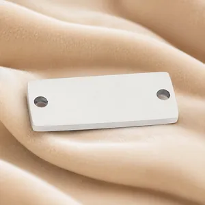 Detailweergave van een gepolijste roestvrijstalen rechthoekige connector met twee gaten.
